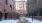 a snowy street between brick buildings